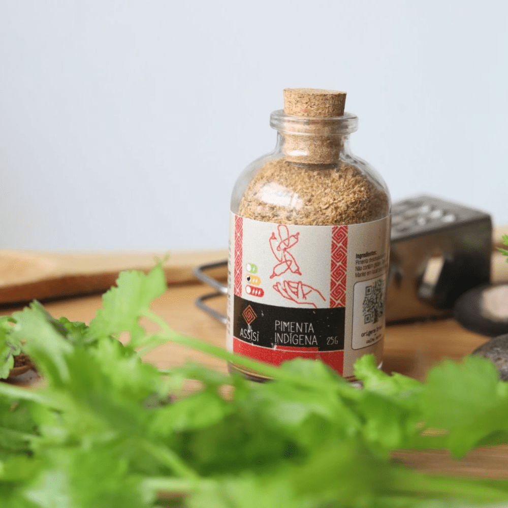 Flacon de piment fumé Wai Wai devant un feuillage vert