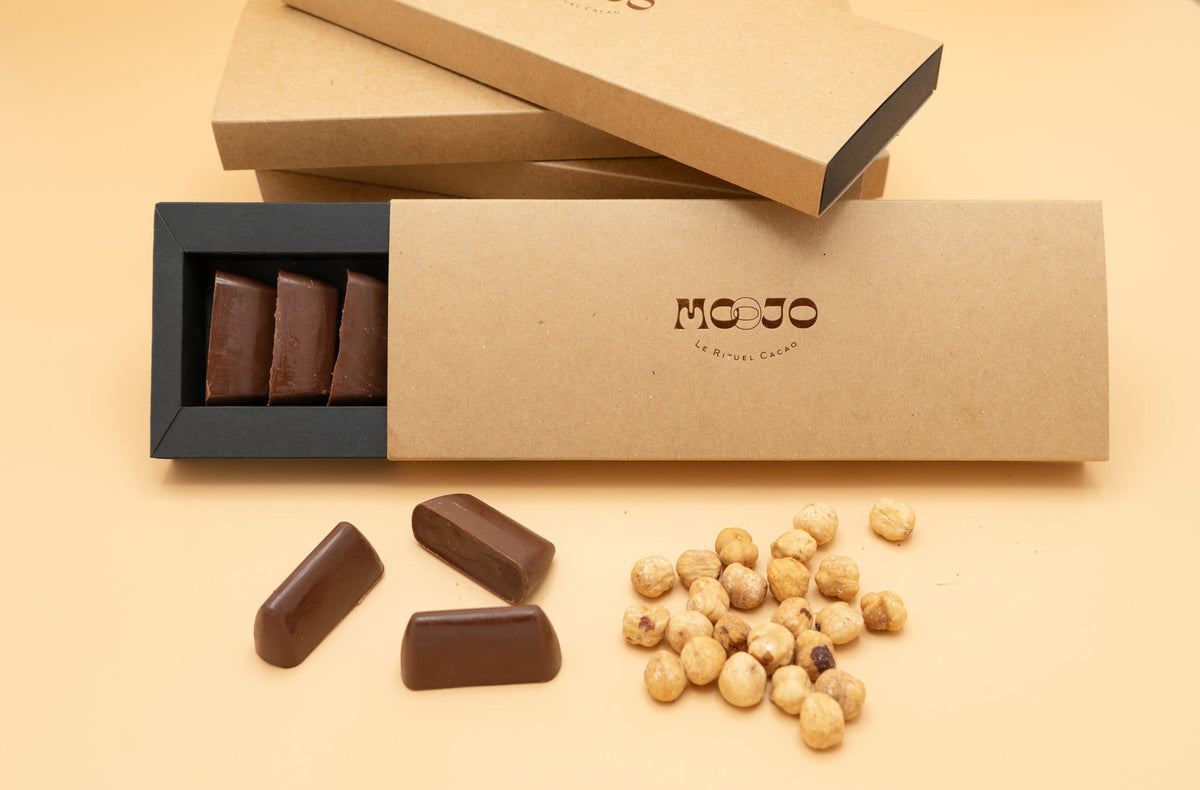 Offene MOOJO-Schachtel mit Giandujotti, dazu Haselnüsse
