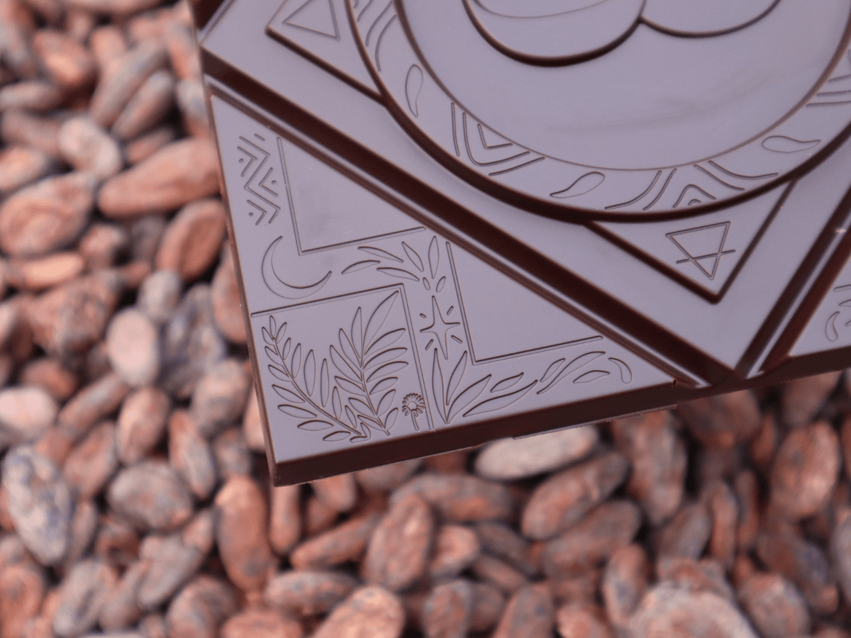 Gros plan d'une tablette de chocolat noir MOOJO sur un lit de fèves · Guatemala Acopio