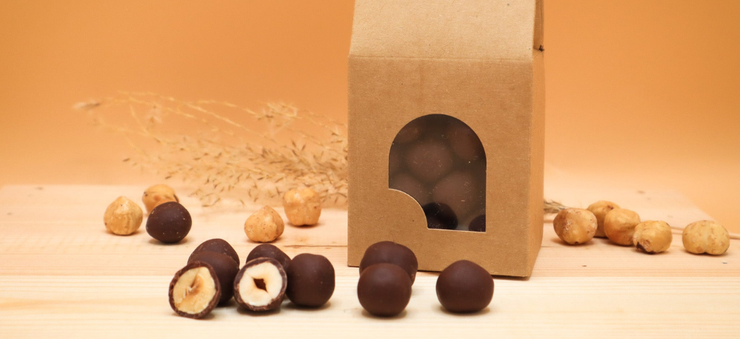 Sachet ouvert et dragées de noisette enrobées