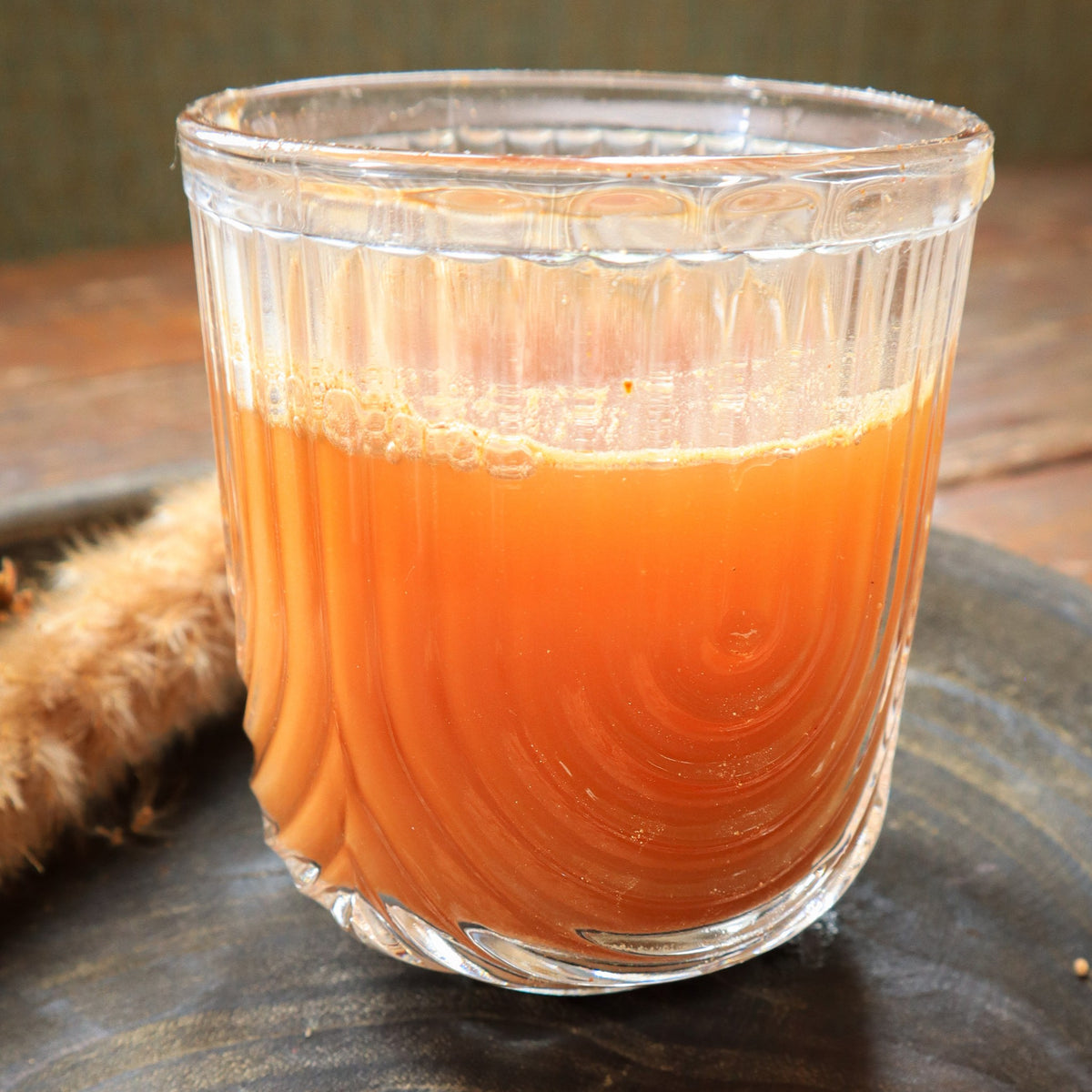 Verre de jus orangé et trait de poudre de camu camu