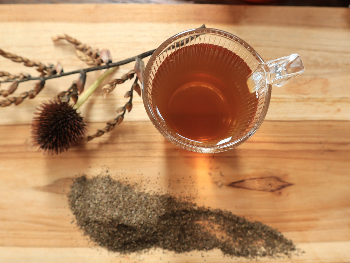 Cup of guayusa infusion and ground leaves, seen from above