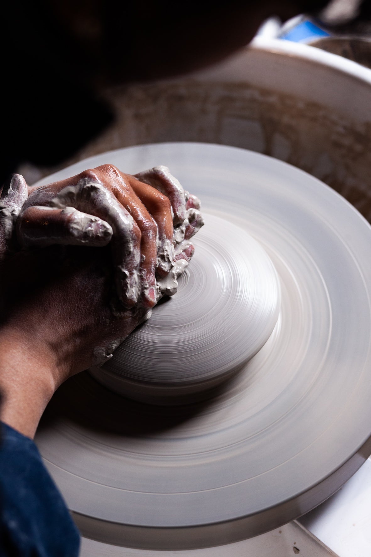 Mains centrant l'argile sur le tour, dans l'atelier de Nisha Ceramic à Bruxelles