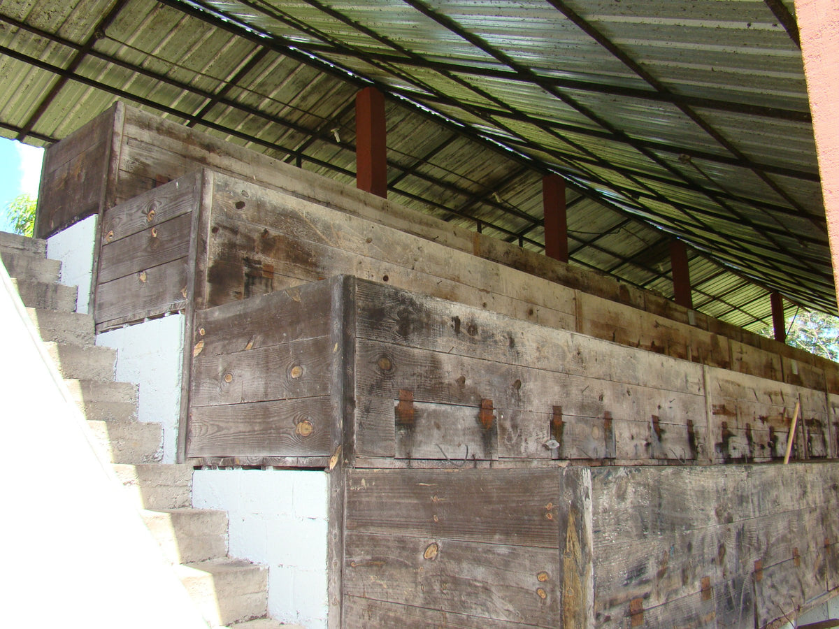 Cajas de fermentación de madera escalonadas junto a una escalera, bajo un techo de chapa